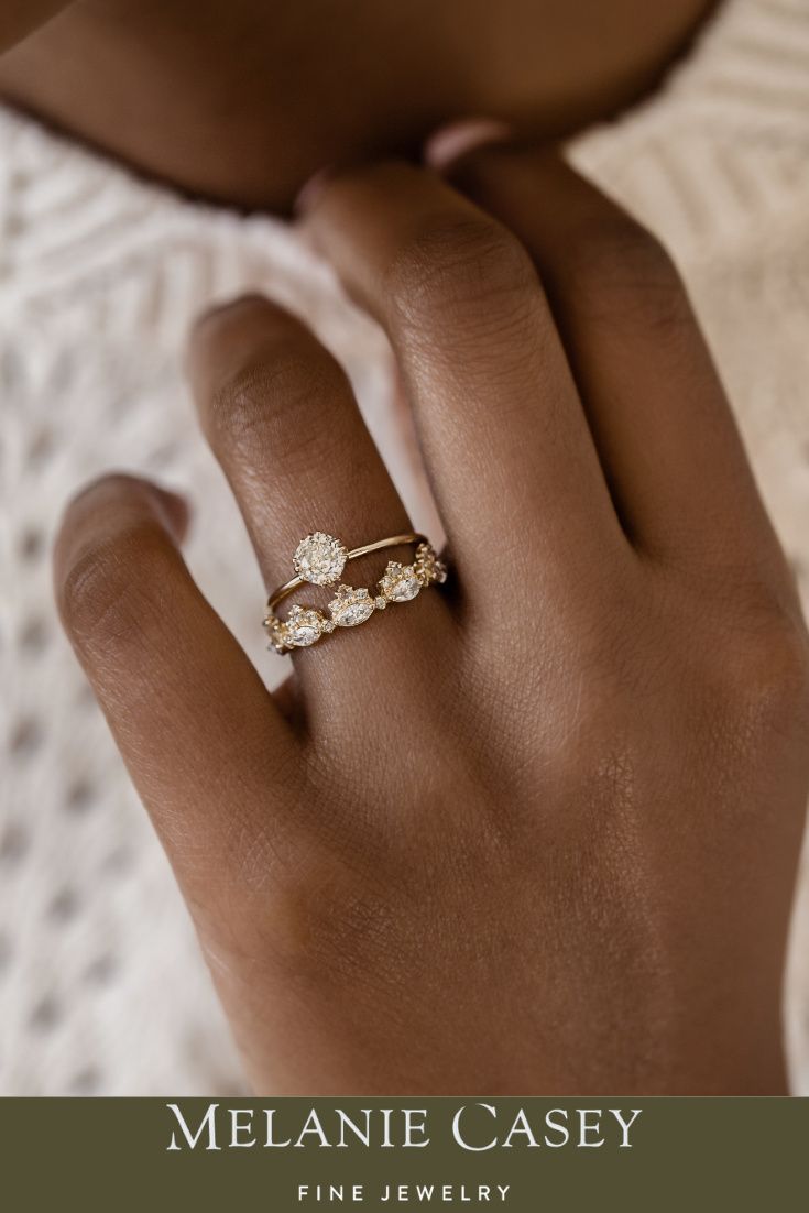 a woman's hand wearing a gold ring with three small flowers on the side