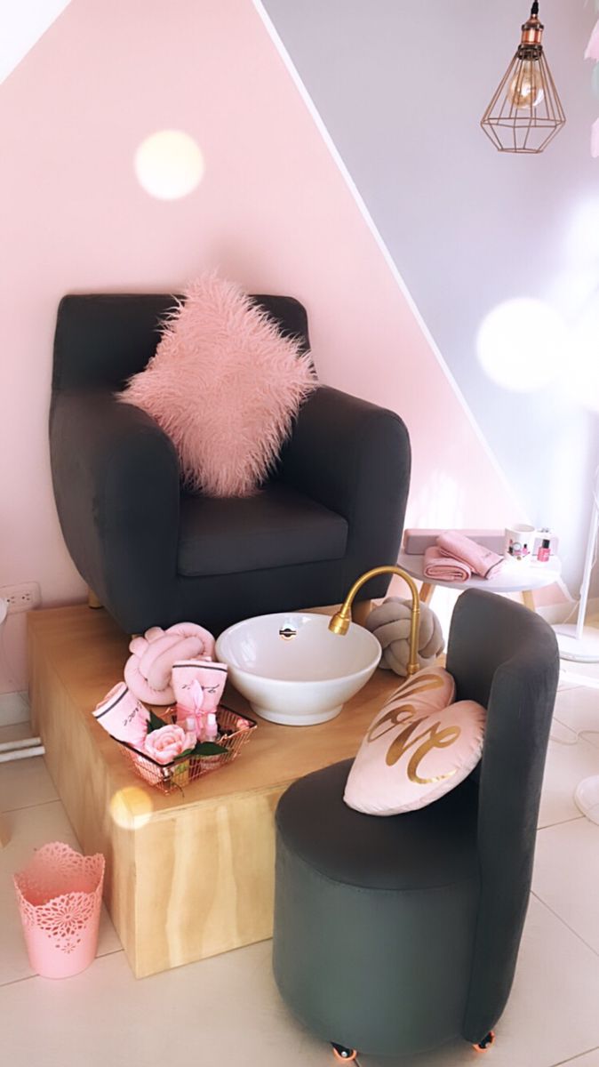 a chair and foot stool in a room with pink accents on the walls, along with other furniture