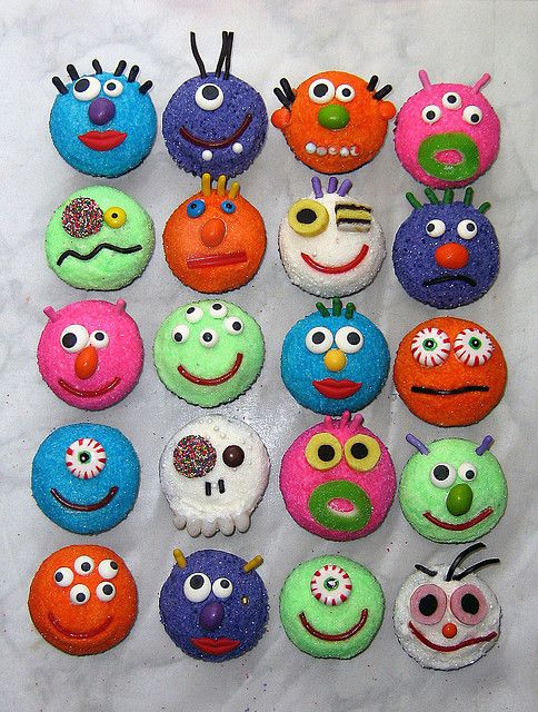 there are many different colored donuts with faces on them, all decorated in the same style