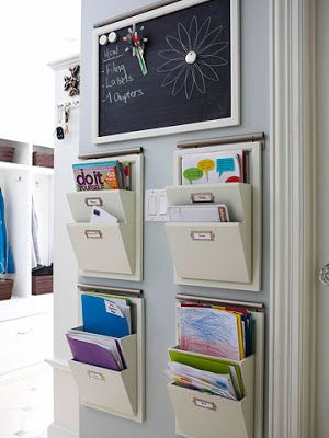 an organized wall hanging with file folders and chalkboard on the door way in a home office