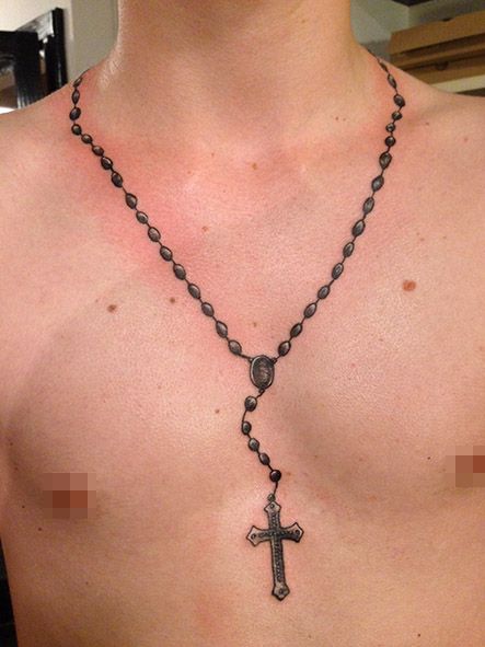 the man is wearing a rosary necklace with a cross on it's chest,