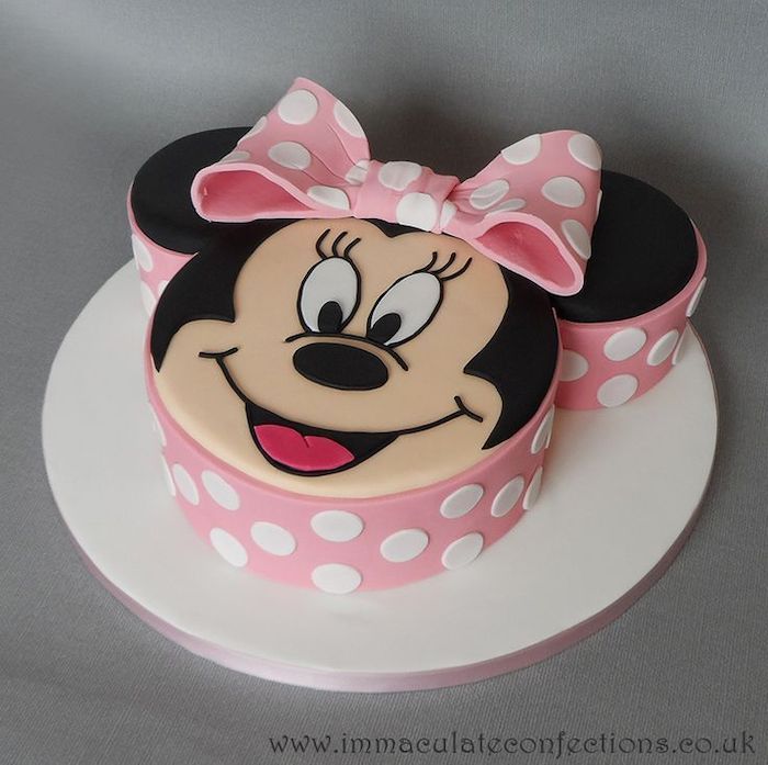 a minnie mouse cake with polka dots and a pink bow on it's head