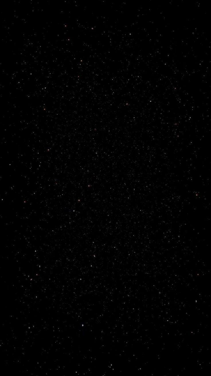 the sky is very dark and it looks like there are stars in the sky above