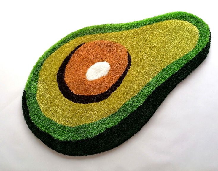 an avocado shaped rug on top of a white surface with a hole in the middle