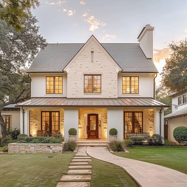 a white house with stone steps leading up to the front door