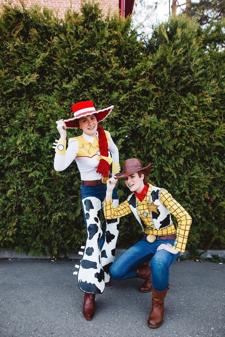 two people dressed as woody and toy story characters posing for a photo in front of bushes