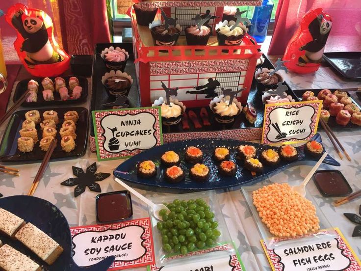 a table topped with lots of desserts and candy bar signs on top of it