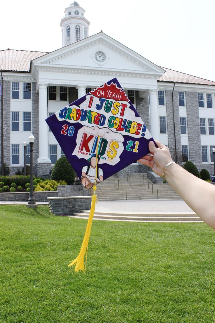 a person holding up a kite with writing on it in front of a large building