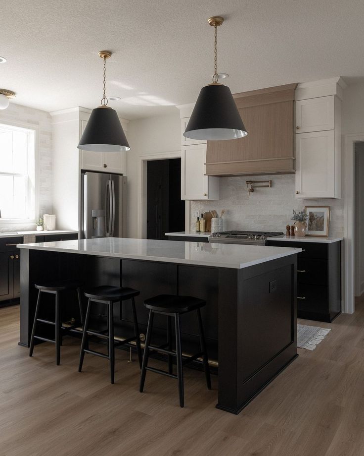 a kitchen with an island and two pendant lights hanging from it's ceiling over the sink