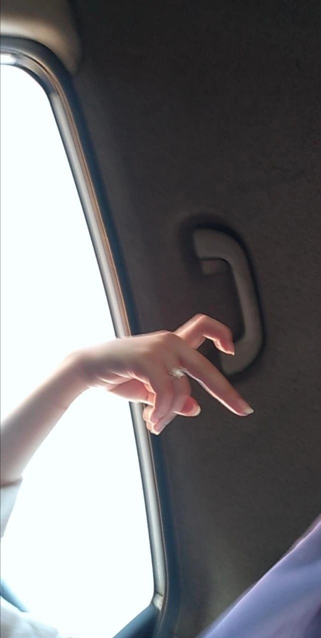 a person's hand reaching out the window of a car