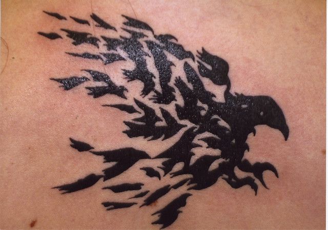 an eagle tattoo on the back of a man's shoulder