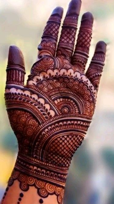 the hand is decorated with henna designs