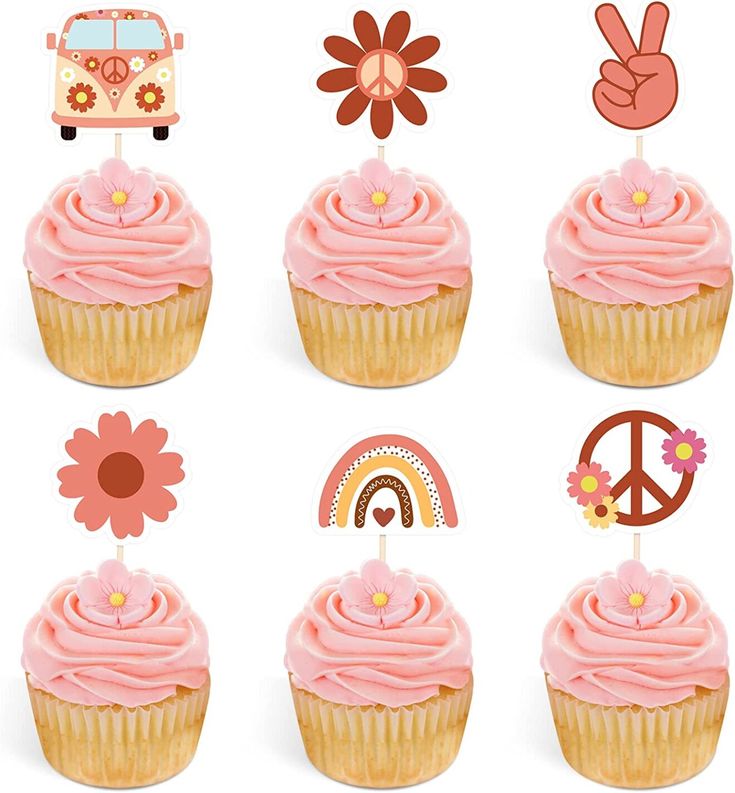 the cupcakes are decorated with pink frosting and peace signs, flowers, and symbols