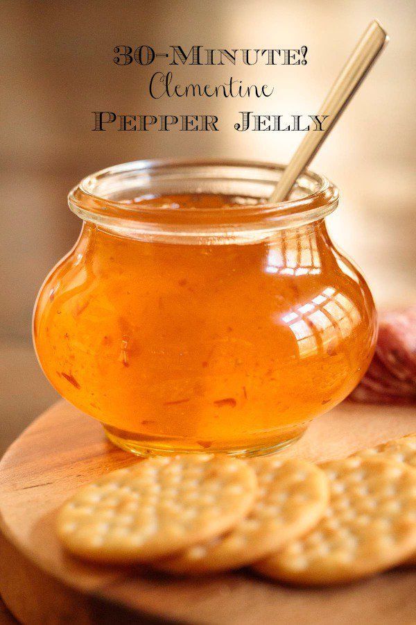 a jar filled with honey sitting on top of a wooden cutting board next to crackers