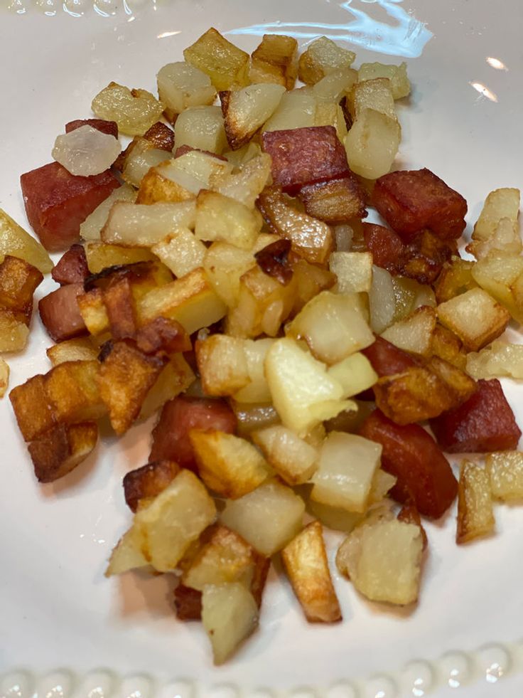 cooked potatoes and bacon on a white plate