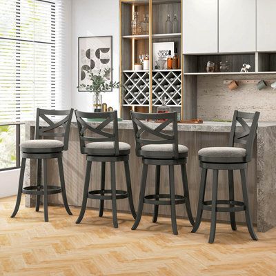 four stools in front of a bar with wine bottles on the shelves behind it