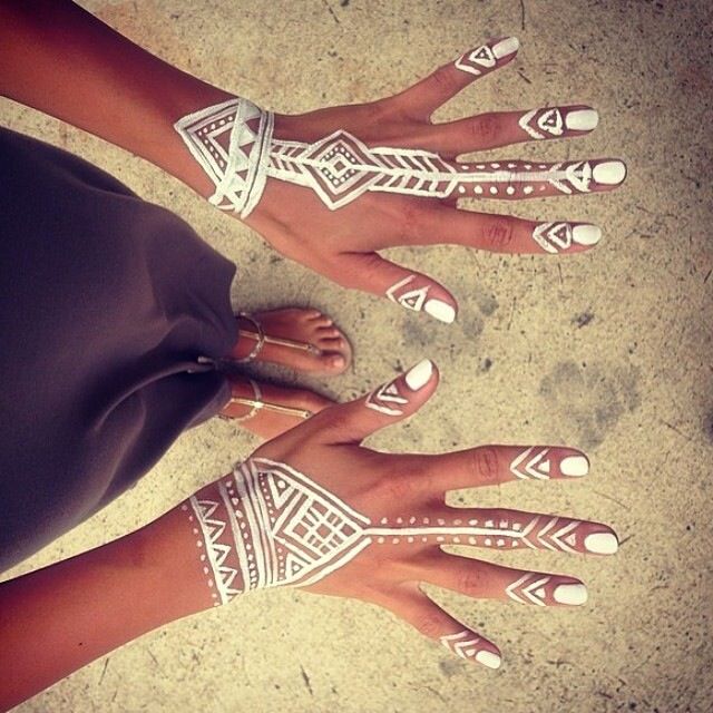 two women with white painted nails and tattoos on their hands