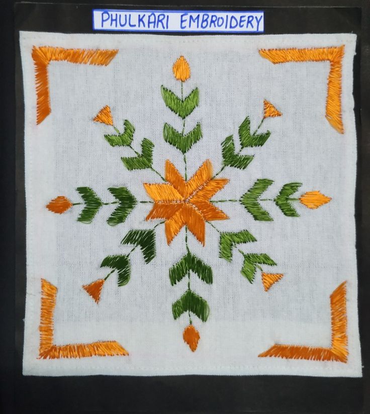 an embroidered piece with orange and green leaves on it's border, in the shape of a flower