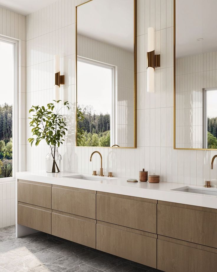 a bathroom with two sinks, mirrors and a plant in the middle of the room