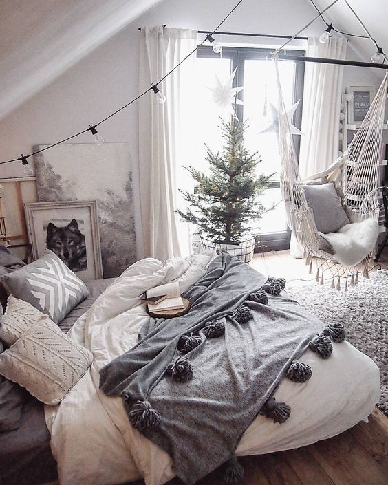 a bedroom with a hammock, bed and christmas tree in the corner on the floor