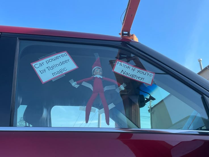 an elf is sitting in the driver's seat of a car with signs on it