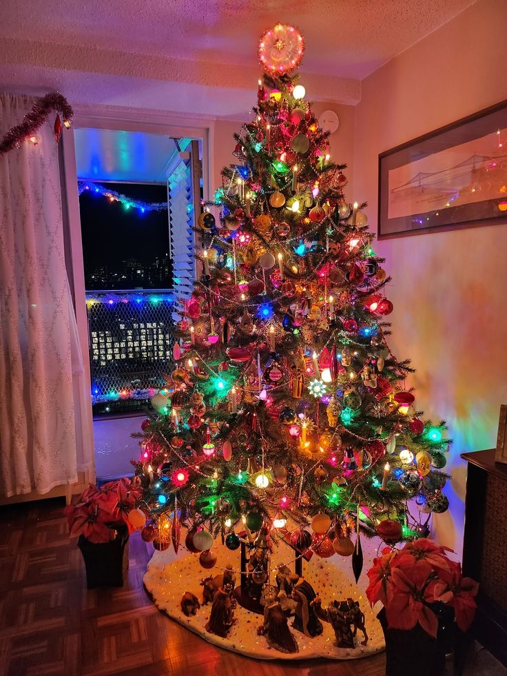 a brightly lit christmas tree in a living room