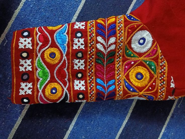 a red shirt with colorful embroidered designs on it