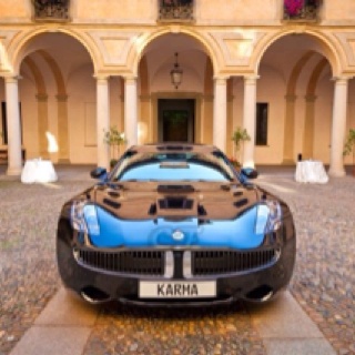 a blue and black car parked in front of a building with arches on it's sides