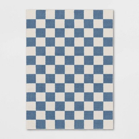 a blue and white checkered rug on a wall