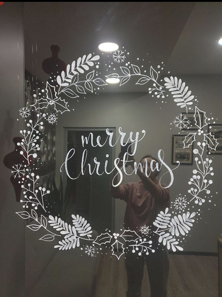 a person taking a selfie in front of a mirror with the words merry christmas written on it