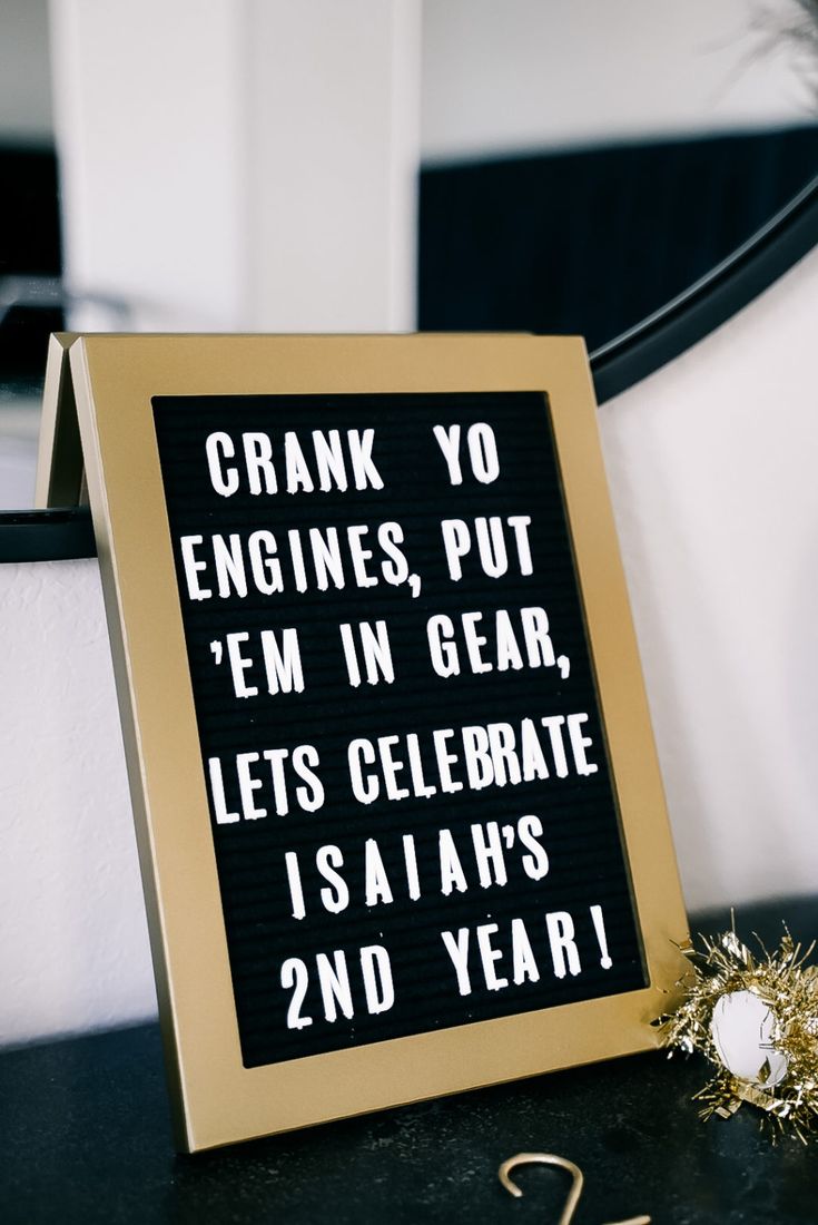 a black and gold framed sign sitting on top of a table next to a candle