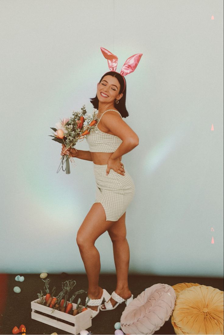 a woman wearing bunny ears and holding flowers