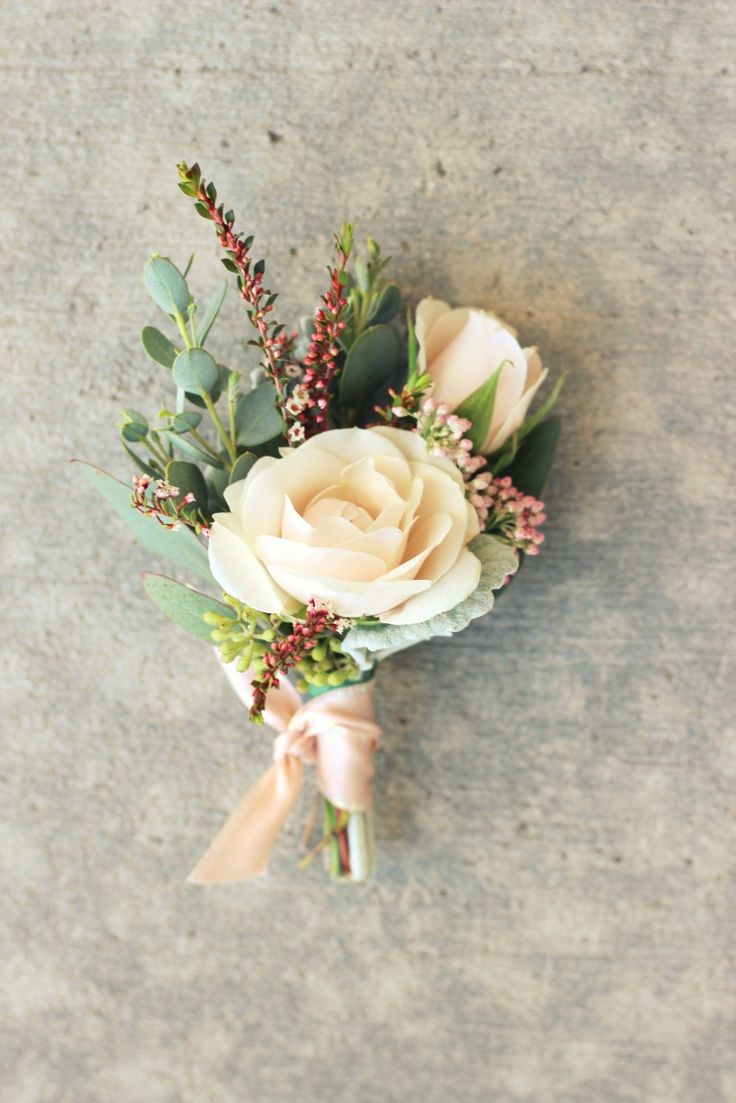 a boutonniere with white roses and greenery