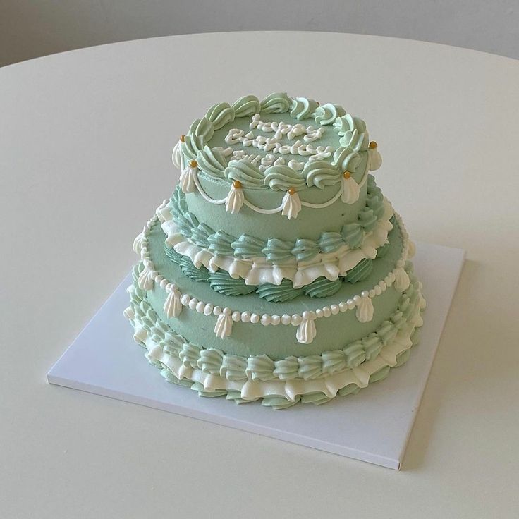 a three tiered cake sitting on top of a white table next to the words feliz cumpleanos domino