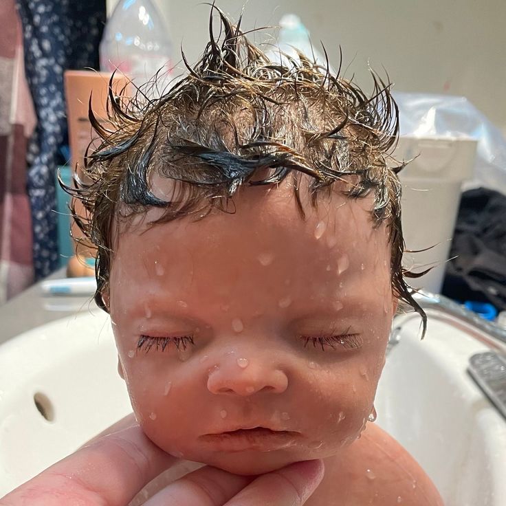 a close up of a baby in a bath tub with water on it's head