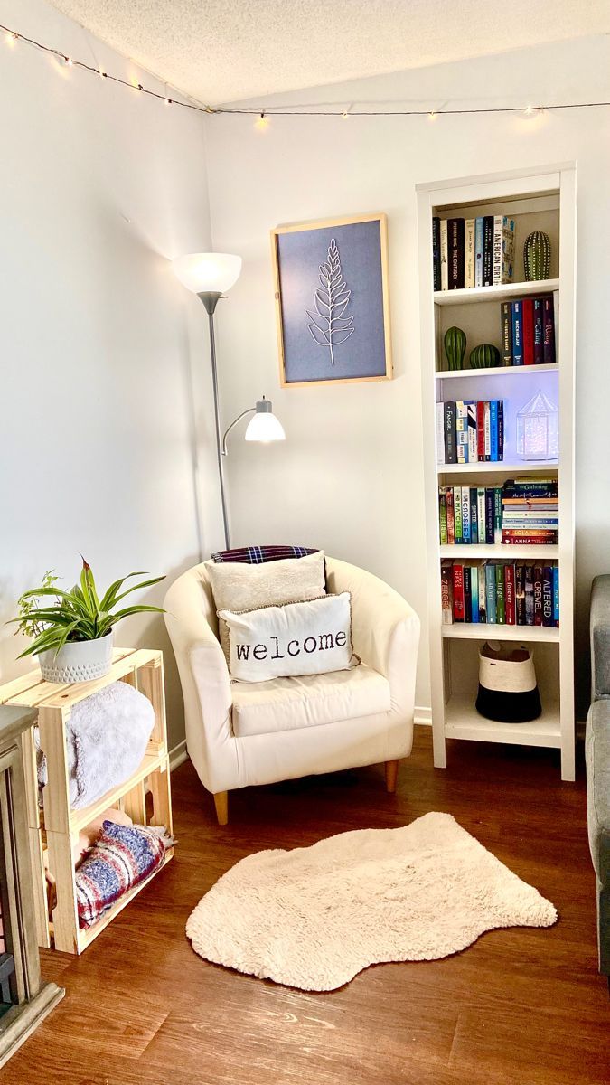 a living room filled with furniture and bookshelves next to a lamp on a wooden floor