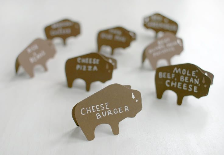 small cutouts of different types of cheese on a white surface with the words cheese burger written across them