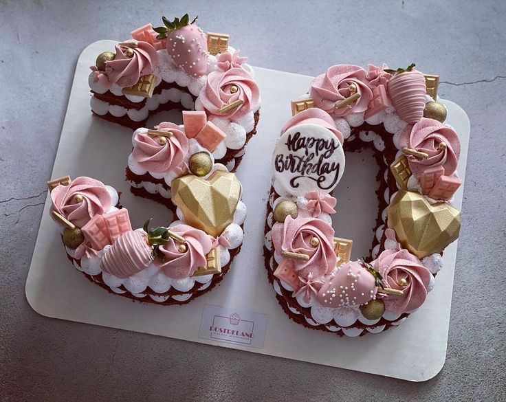 a cake shaped like the number 50 with pink and gold decorations