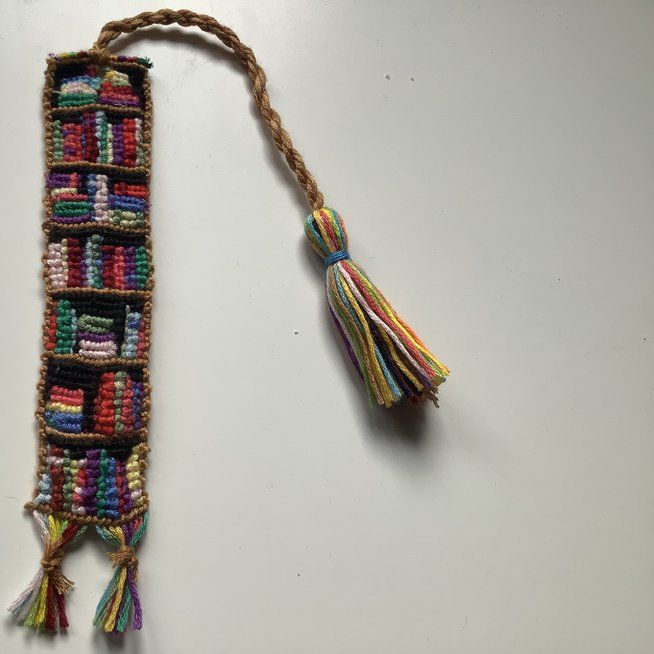 a tasseled bookmark with multicolored books on it