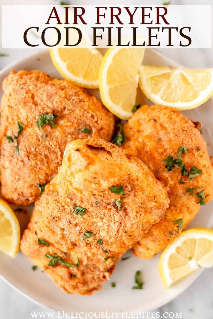 air fryer chicken fillets on a white plate with lemons and parsley