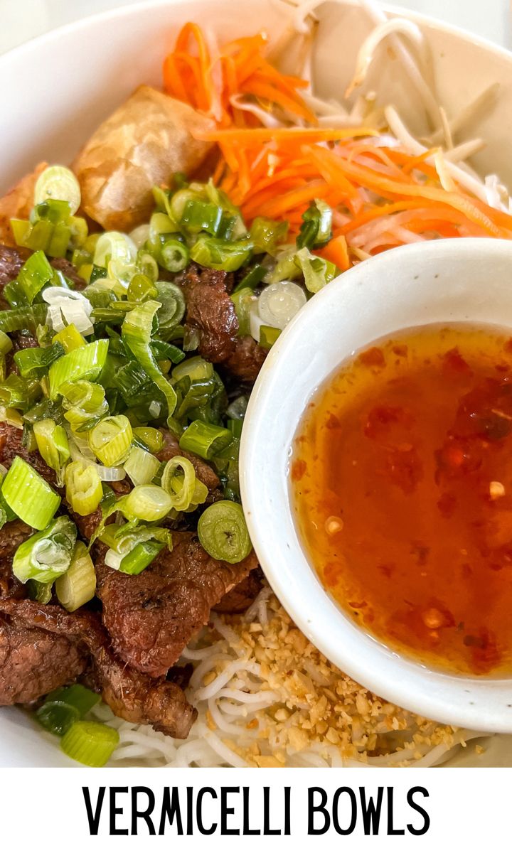 a bowl filled with meat and veggies next to some dipping sauce on top of rice