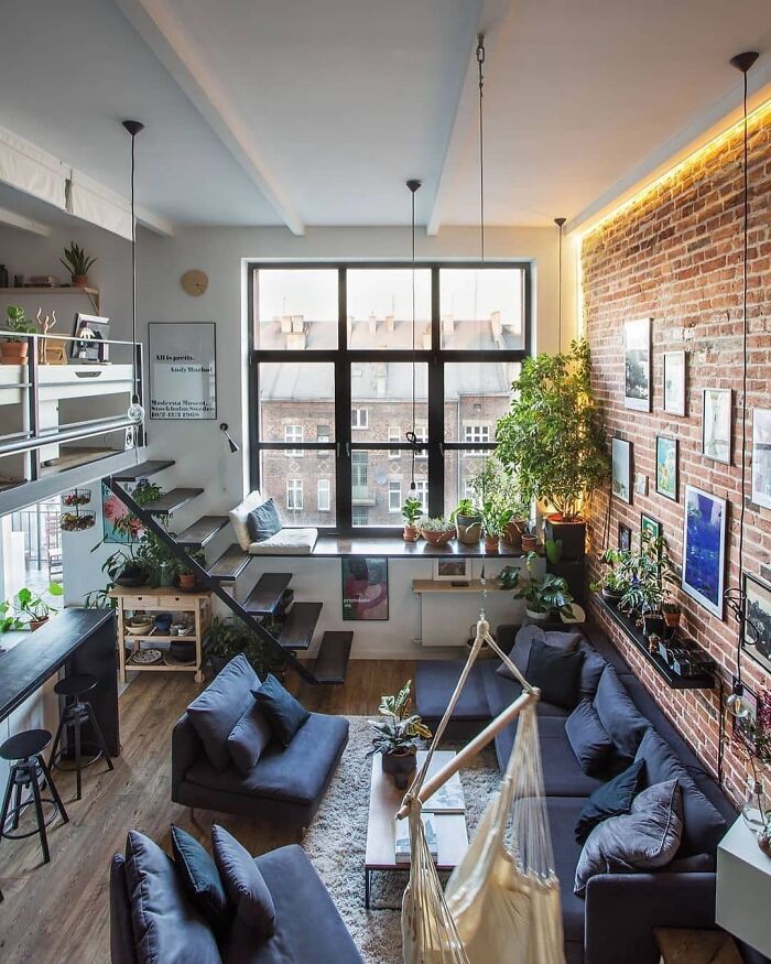 a living room filled with furniture and lots of windows next to a wall mounted tv