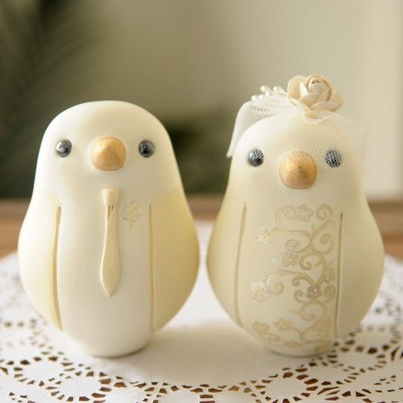 two wedding cake toppers are sitting on a doily