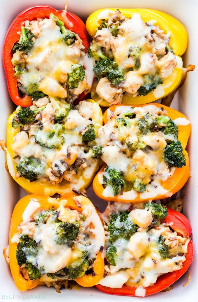 stuffed bell peppers with chicken and broccoli in a white casserole dish