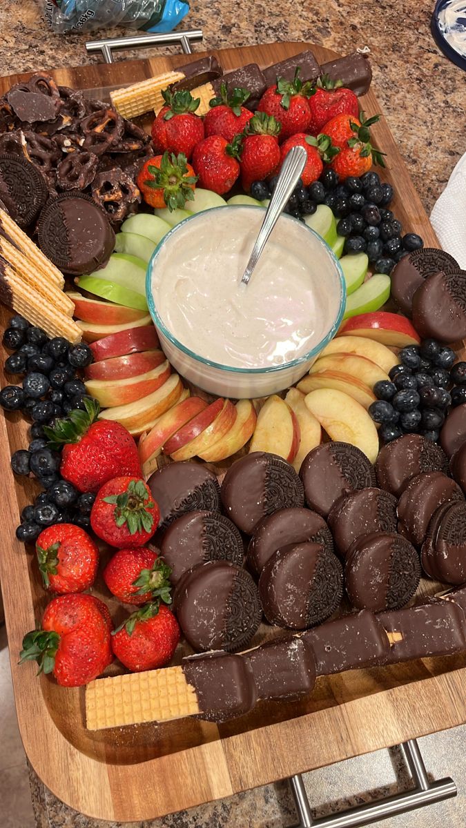 a platter filled with chocolate covered strawberries, apples, and other fruit toppings