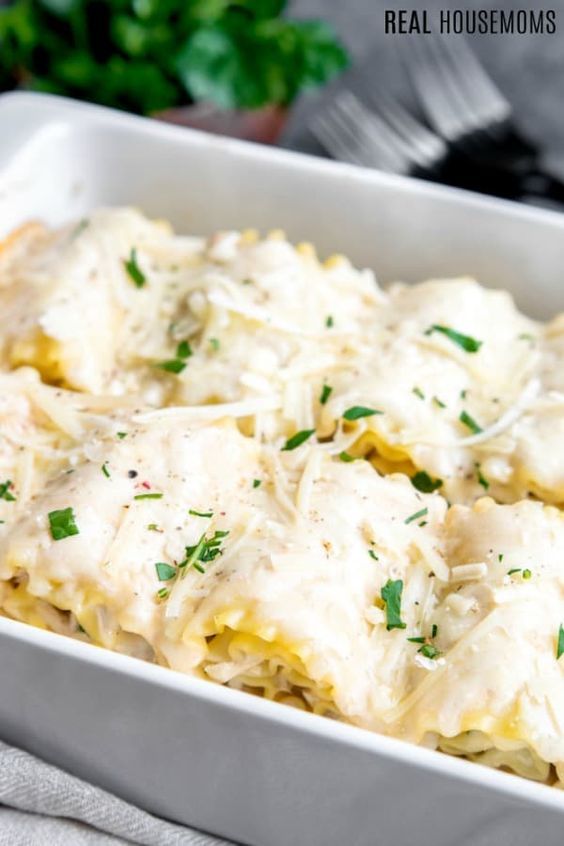 a casserole dish with cheese sauce and parsley on top, ready to be eaten