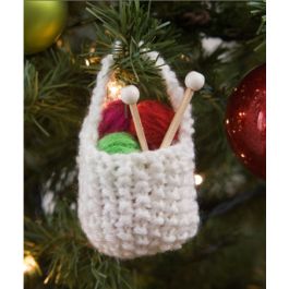 an ornament hanging from a christmas tree with knitting needles and yarn in it