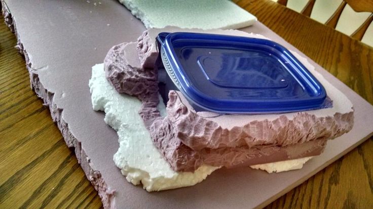 a piece of cake sitting on top of a wooden table next to a blue container