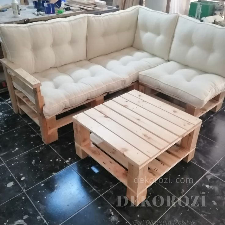 a couch and table made out of wooden pallets in a room with tile flooring