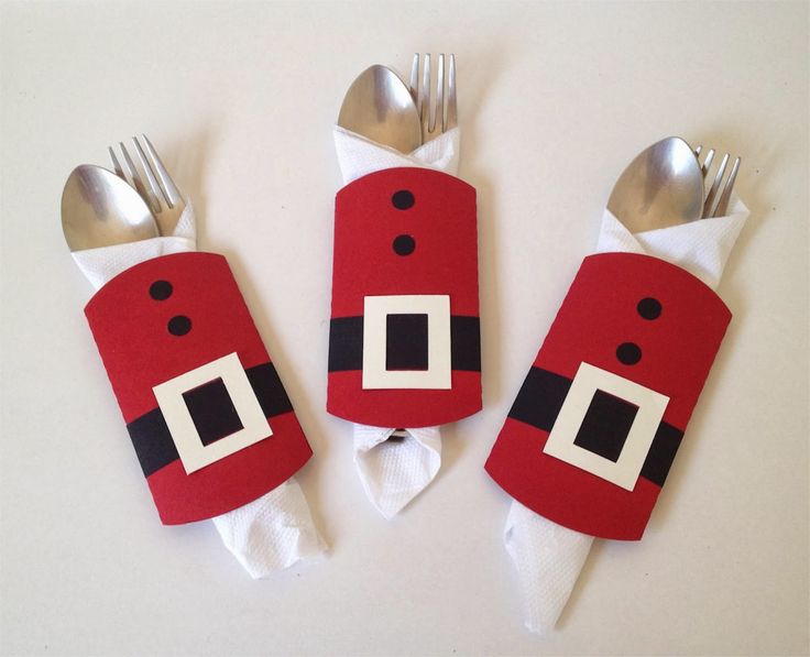 three forks and two napkins made to look like santa claus